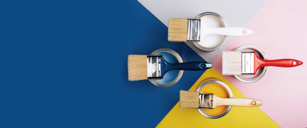 istock Four open cans of paint with brushes on them on bright symmetry background. 1192091973