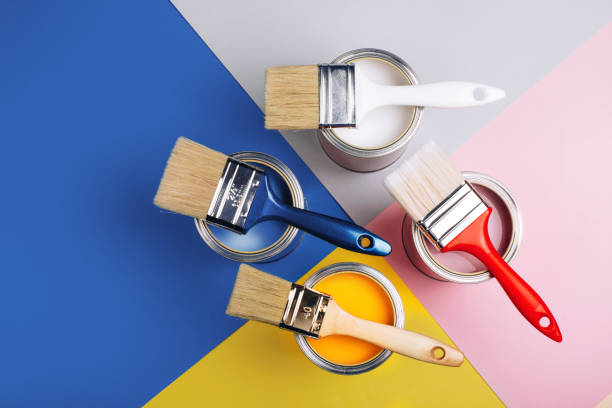 istock Four open cans with brushes on them on bright symmetry background. 1192091975
