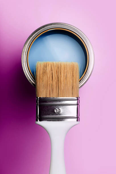 istock Brush on open can of turquoise paint on blue pastel background. 1192091981