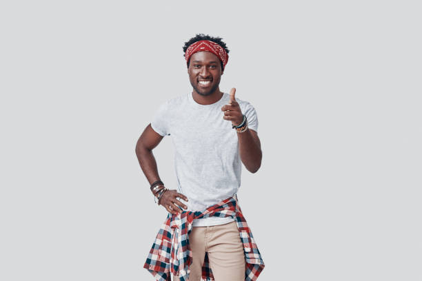 istock Handsome young African man looking at camera and smiling while standing against grey background 1192091984