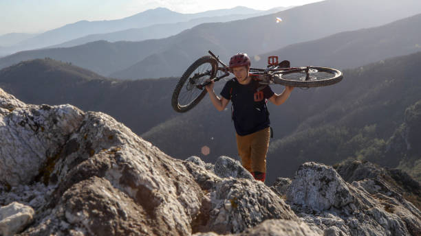 o motociclista da montanha carreg a bicicleta à parte superior do penhasco - 13414 - fotografias e filmes do acervo