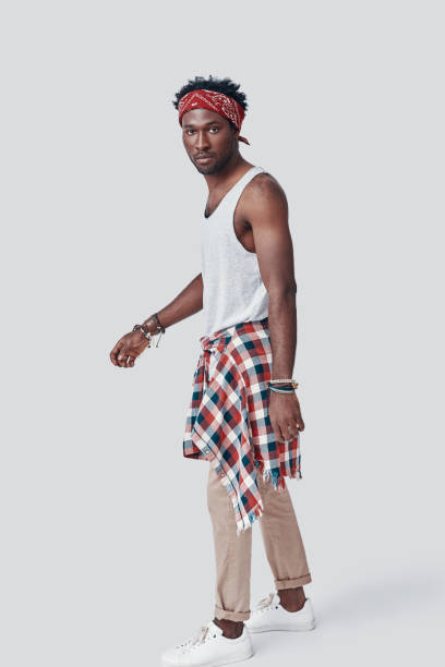 istock Full length of handsome young African man looking at camera while standing against grey background 1192092779