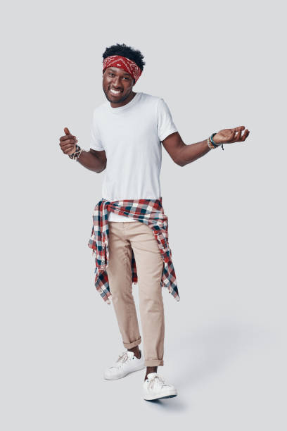 istock Full length of handsome young African man looking at camera and smiling while standing against grey background 1192092832