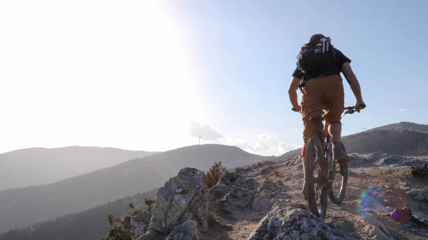istock Mountain biker rides up trail at sunrise 1192093088