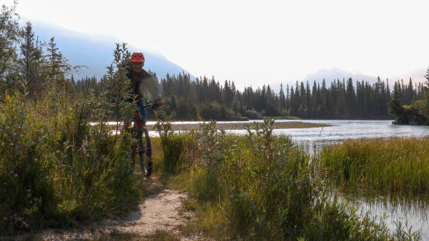 istock Mountain biker rides down trail near river 1192094210