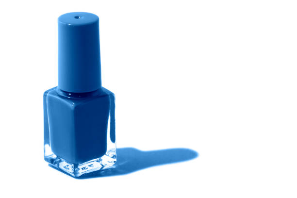 Photography on the theme of the trend color 2020. Isolated blue nail bottle on a white background with a place for the inscription.
