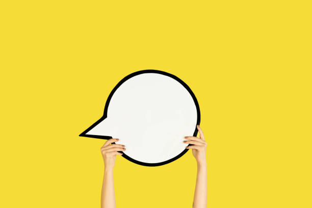 istock Hands holding the sign of comment on yellow studio background 1192094477