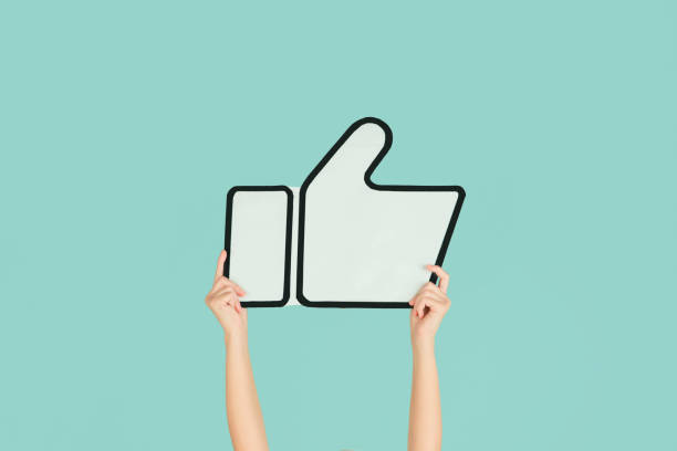 istock Hands holding the sign of like on blue studio background 1192094547