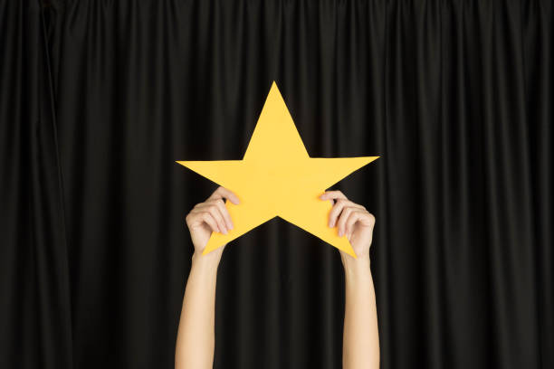 istock Hands holding the sign of star on black studio background 1192094589