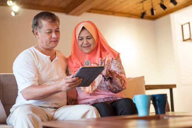 istock Senior Asian couple at home using digital tablet 1192094769