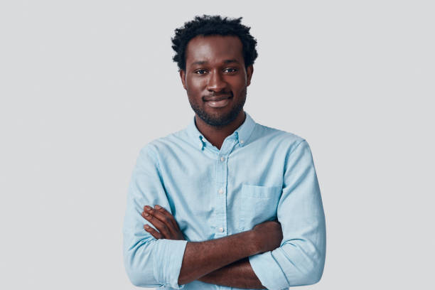 istock Handsome young African man looking at camera and keeping arms crossed while standing against grey background 1192094797