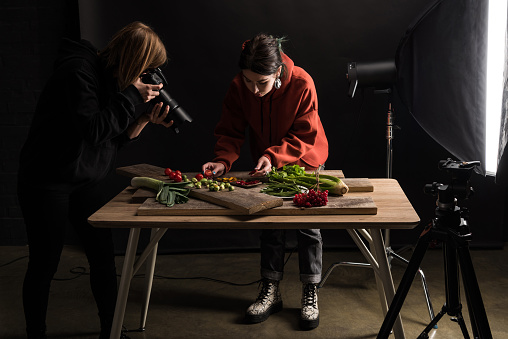 two photographers making food composition for commercial photography and taking photo on digital camera