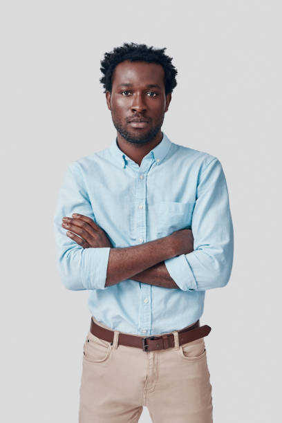 istock Handsome young African man looking at camera and keeping arms crossed while standing against grey background 1192094884