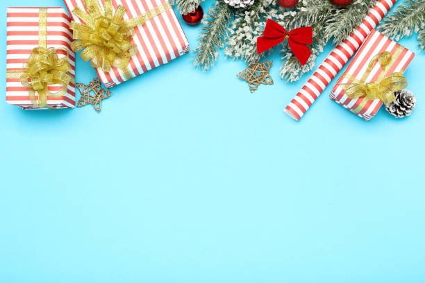 istock Gift boxes with christmas ornaments and fir tree branches on blue background 1192094889