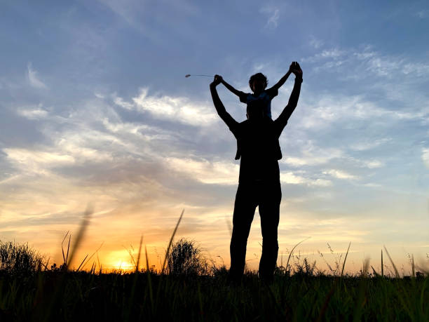 istock Silhouette Father Carrying Son Against Sky During Sunset 1192095969