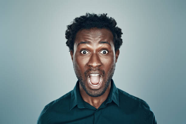 istock Surprised young African man looking at camera and keeping mouth open while standing against grey background 1192096030