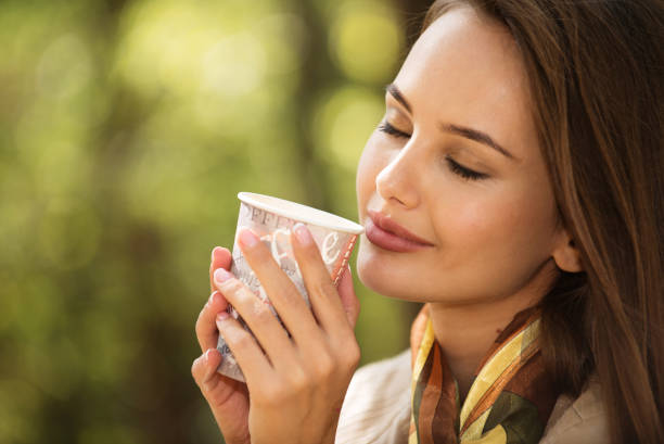 istock Beautiful young girl  drinks coffee  autumn park. 1192096187