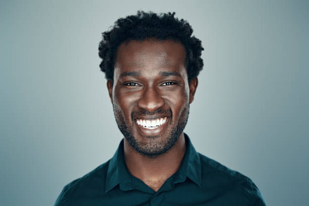 istock Handsome young African man looking at camera and smiling while standing against grey background 1192096414