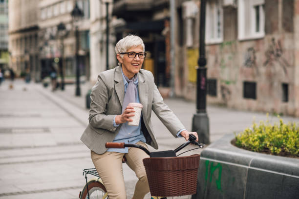 istock Senior woman cycling to work and drinking coffee 1192097865
