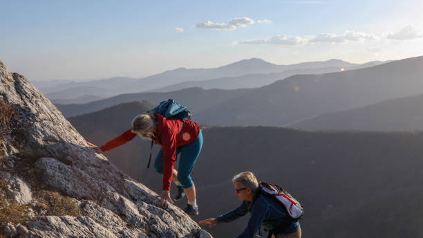 istock Mature couple scramble up mountain ridge 1192100319
