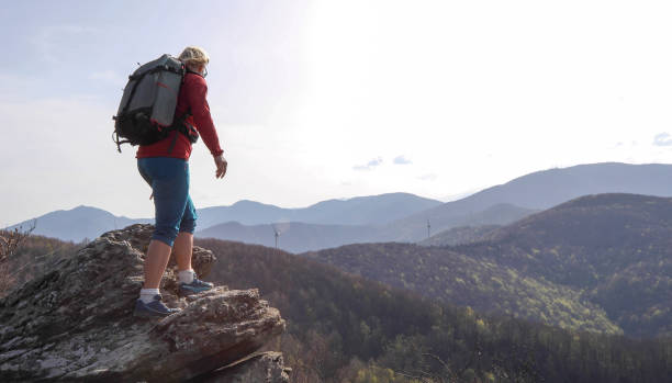 istock Mature woman relaxes on mountain ridge 1192100325