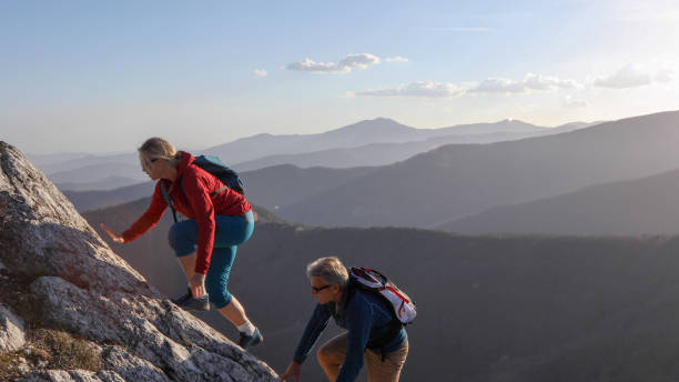 istock Mature couple scramble up mountain ridge 1192100446