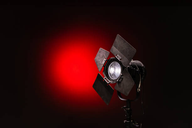 istock Spotlight with directional light with a Fresnel lens on black and red background 1192100542