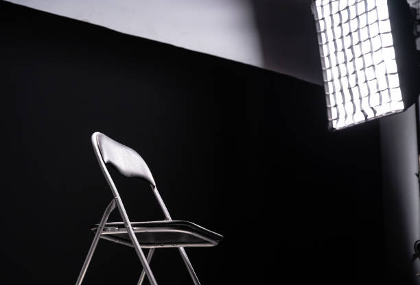 Empty foldable chair on black background, lighting equipment Empty foldable chair on black background. The scene is located in a studio environment. The footage is taken with Sony A7III camera dimmer switch photos stock pictures, royalty-free photos & images