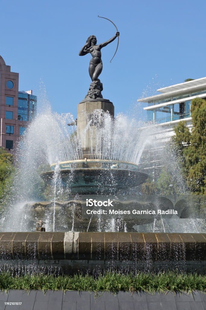 Sculpture of the Diana Huntress in the center of a water fountain in roundabout on Avenida Paseo de la Reforma in Mexico City. Sculpture of the Diana Cazadora in the center of a water fountain in a roundabout on Paseo de la Reforma Avenue in Mexico City. Architecture Stock Photo