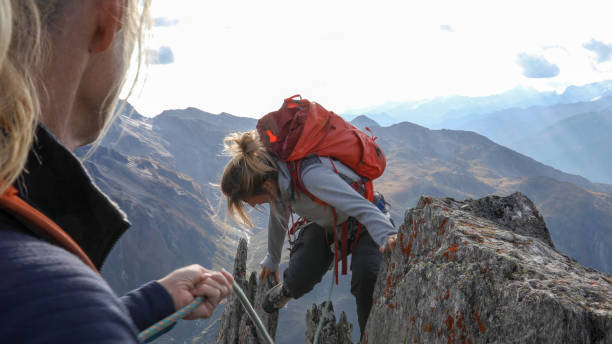 istock Female mountaineer scrambles up mountain ridge 1192101527