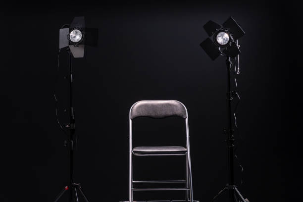 istock Black chair and two led spot lights on black background 1192101549