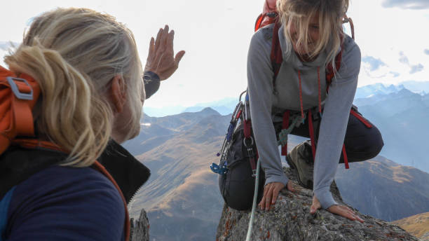 istock Female mountaineer scrambles up mountain ridge 1192101627