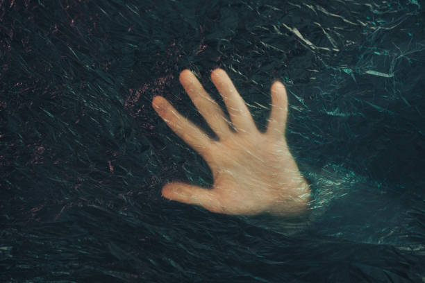 istock Beautiful abstract plastic cellophane  bag background. Human hand shows palm help stop.  No Plastic Bag Concept, save world, protect earth. 1192101785