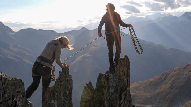 istock Female mountaineer scrambles up mountain ridge 1192101908