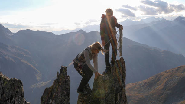 istock Female mountaineer scrambles up mountain ridge 1192102028