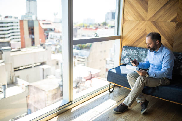 istock Mature man writing on paper and using smart phone 1192102073