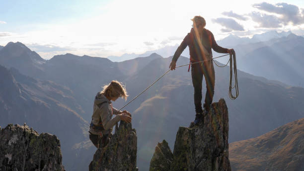 alpinista donna si arrampica sulla cresta della montagna - exploration mountain teamwork mountain peak foto e immagini stock