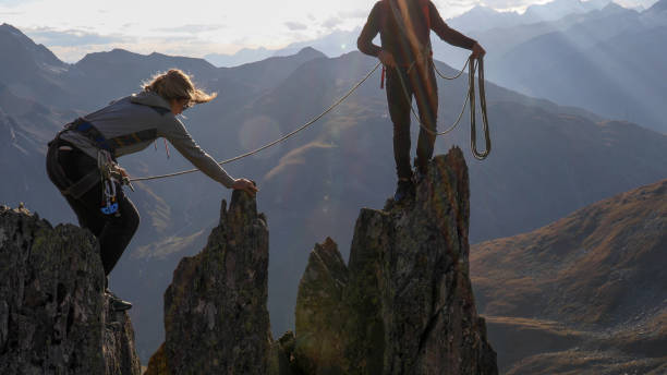 istock Female mountaineer scrambles up mountain ridge 1192102246