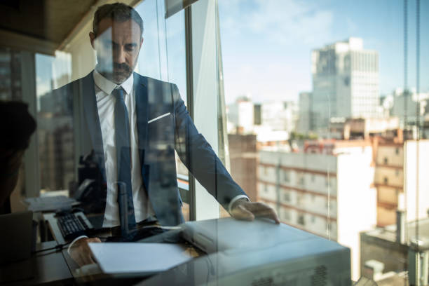 istock Latino businessman using photocopier at work 1192102330
