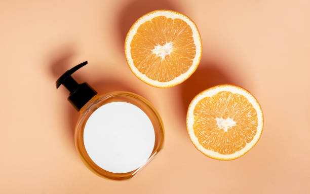 istock Cosmetic bottle container with fresh orange slices on an beige background 1192103256