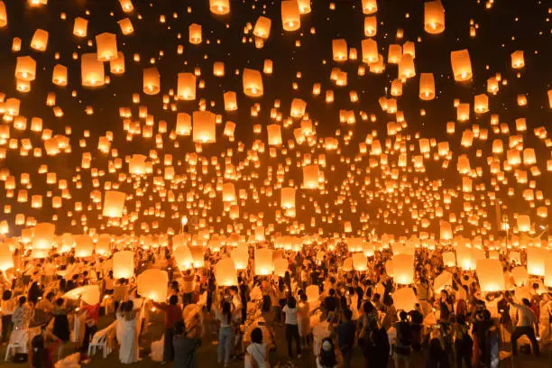 Thai people release sky floating lanterns or lamp to worship Buddha's relics at night. Traditional festival in Chiang mai, Thailand. Loy krathong and Yi Peng Lanna ceremony. Celebration background.