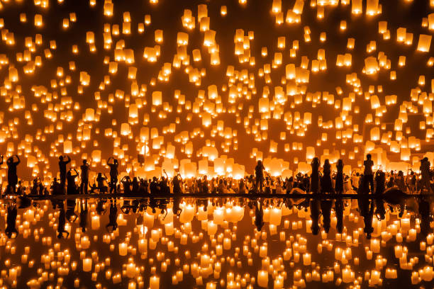 Thai people release sky floating lanterns or lamp to worship Buddha's relics with reflection. Traditional festival in Chiang mai, Thailand. Loy krathong and Yi Peng Lanna ceremony. Celebration. stock photo