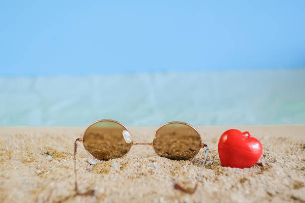 istock Sunglasses eyeware drop on tropical sand beach. 1192105914