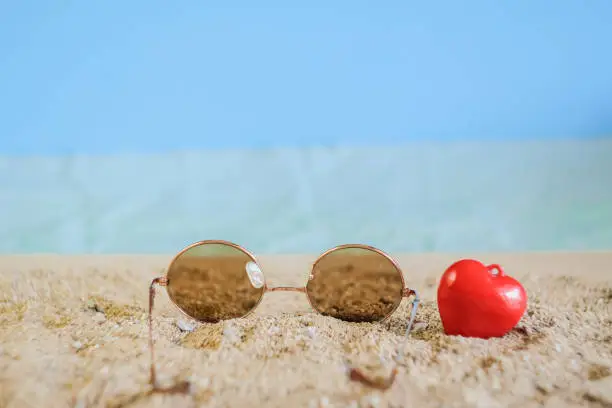 Sunglasses eyeware drop on tropical sand beach.
