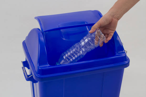 istock woman hand holding empty bottle into the trash isolated 1192106188