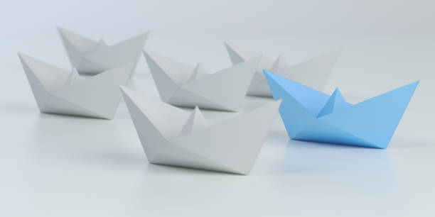 istock Leadership concept with blue paper ship leading among white 1192106313