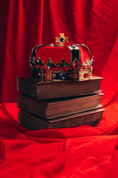 istock ancient golden crown with gemstones on books on red cloth 1192109119