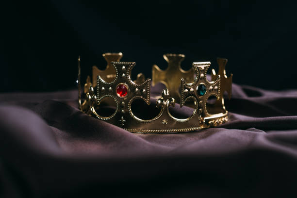 istock retro golden crown with gemstones on black cloth 1192109120