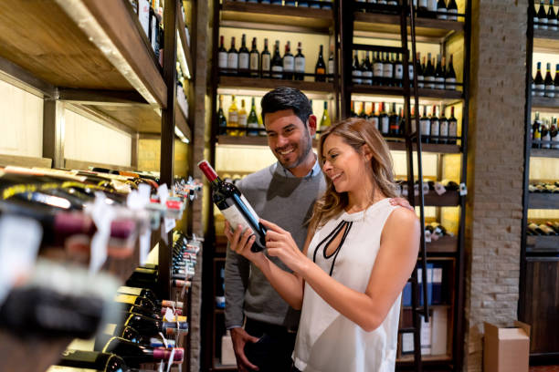 Couple at a wine bar reading the label on a bottle