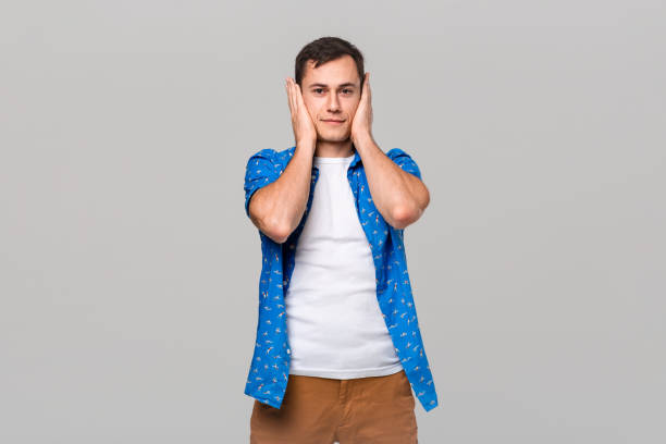 istock Young man covering ears with hands. Gesture of three wise monkeys. 1192114757